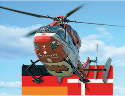 Rettungshubschrauber mit Deutschland- und Dänemarkflagge im Hintergrund