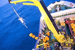 Vogelperspektive: Kran auf einem Schiff bewegt Zubehör